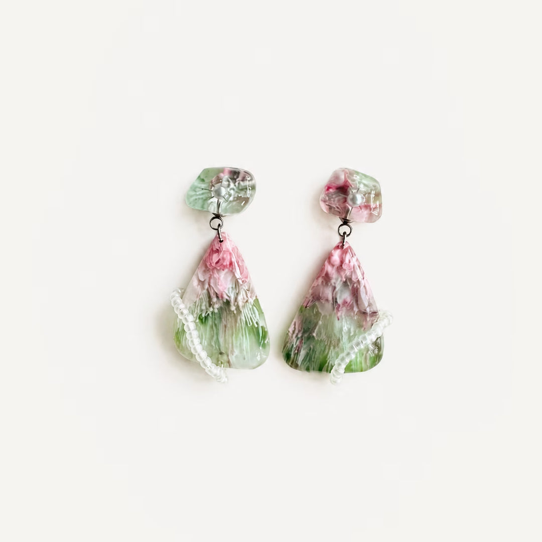 Handcrafted resin statement earrings in translucent pink and green with pearl accents and wrapped bead details from the Imagined Objects collection by Artist Jun.